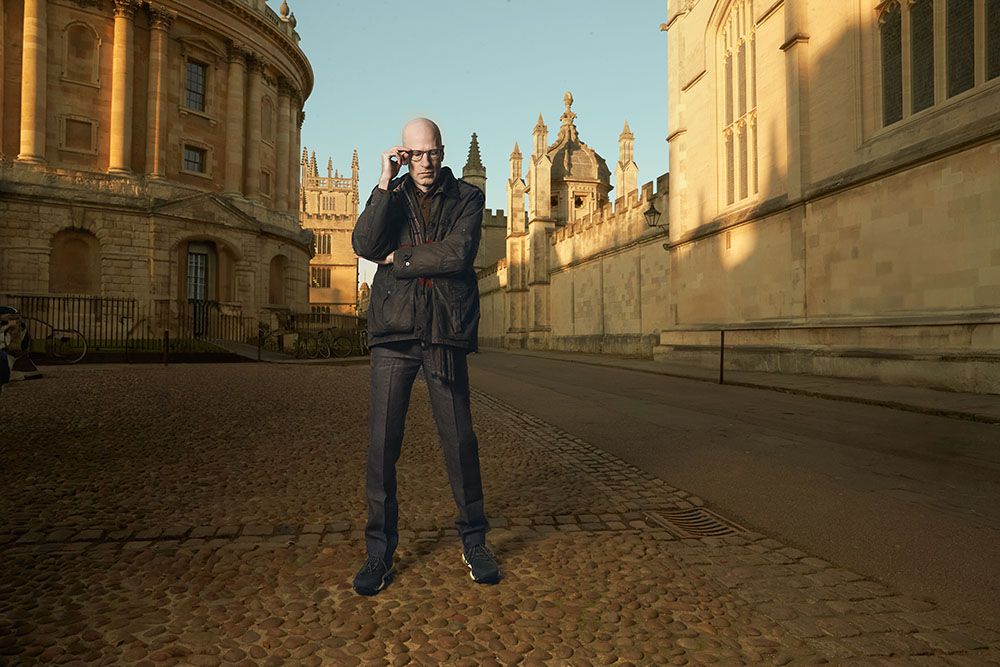Outdoors full-figure portrait of Nick Bostrom in front of old buildings